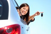 stock photo of multiracial  - Woman driver holding car keys driving her new car - JPG 