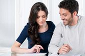 picture of investment  - Happy smiling couple calculating their financial investments at home - JPG 