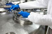 pic of industrial  - hands in gloves opening industrial process tank  - JPG 
