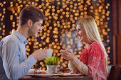 picture of restaurant  - romantic evening date in restaurant  happy young couple with wine glass tea and cake - JPG 