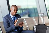 image of black  - black businessman using tablet computer at airport - JPG 