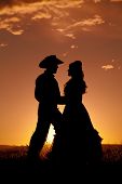 picture of sunset  - A silhouette of a cowboy and a woman dancing in the sunset - JPG 