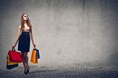 foto of woman  - beautiful woman with many shopping bags on gray background - JPG 