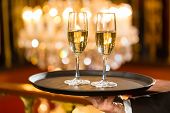 picture of restaurant  - Waiter served champagne glasses on a tray in a fine dining restaurant - JPG 