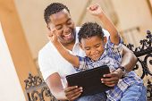 pic of computer  - Happy African American Father and Mixed Race Son Having Fun Using Touch Pad Computer Tablet Outside - JPG 