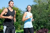 foto of health  - Young fitness couple of man and woman jogging in park - JPG 