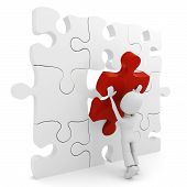 stock photo of puzzle  - 3d man pushing a puzzle piece into its place - JPG 