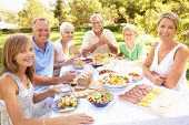 foto of family  - Extended Family Enjoying Meal In Garden - JPG 