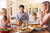 picture of family  - Family Saying Prayer Before Eating Roast Dinner - JPG 