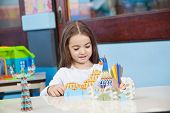 picture of preschool  - Pretty little preschool girl playing with craft in classroom - JPG 