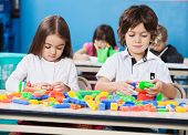 stock photo of construction  - Little children playing with construction blocks in classroom - JPG 