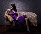stock photo of interior  - The image of a beautiful luxurious woman sitting on a gold vintage couch - JPG 