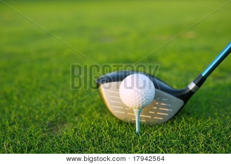 Picture or Photo of Golf tee ball club driver in green grass course closeup