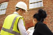 stock photo of property  - A builder contractor or surveyor discussing a property quotation or contract with a homeowner - JPG 