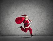 stock photo of holidays  - Santa Claus running with the bag of the presents - JPG 